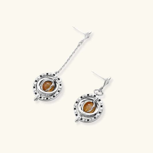 Orbital asymmetric earrings with star-shaped post, black enamel stars, and honey-gold cabochon in silver-toned ring from Najera Studio