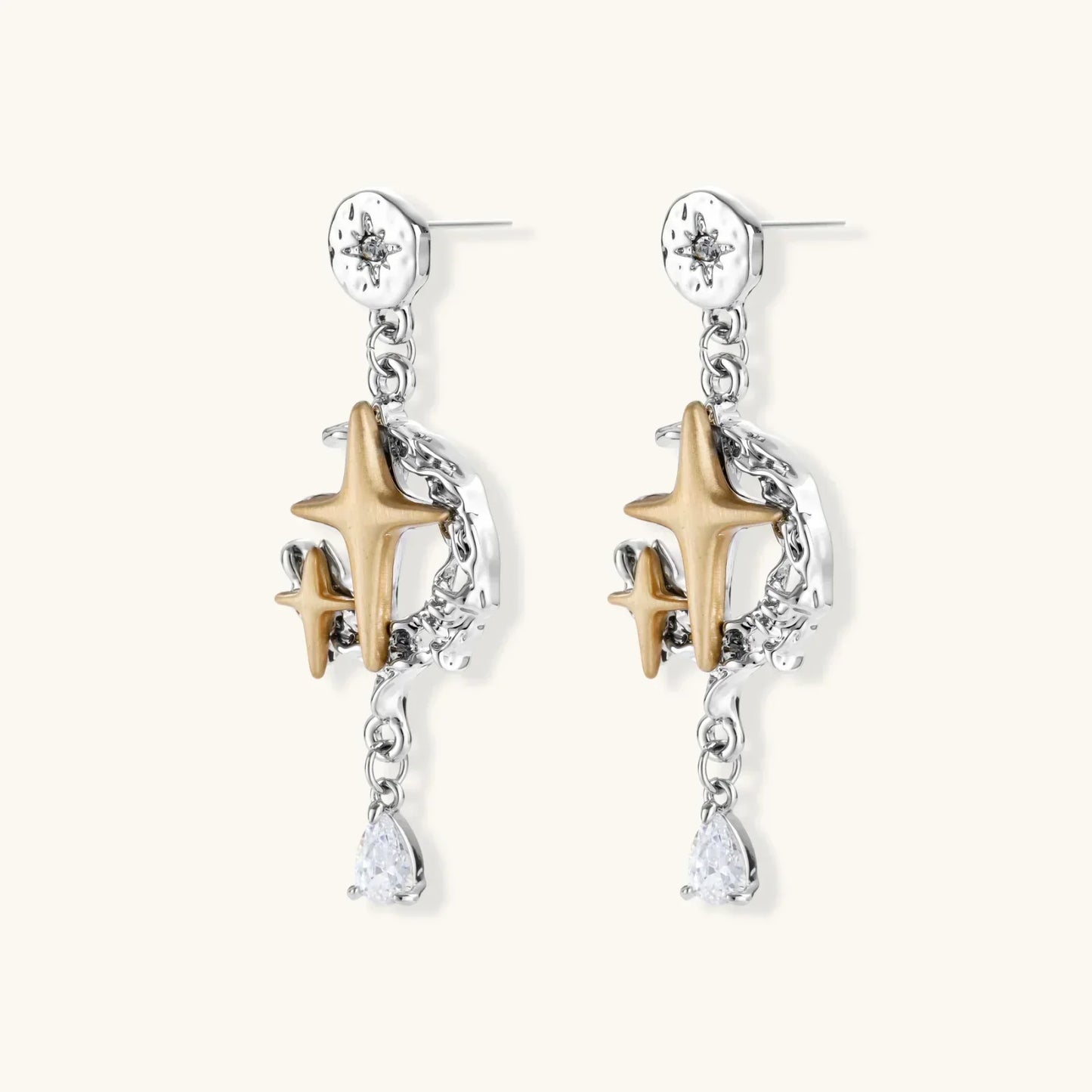 Close-up of Celestial Star Drops earrings featuring mixed-metal design with hammered silver discs, gold four-point stars, silver vines, and pear-cut zirconia gemstones