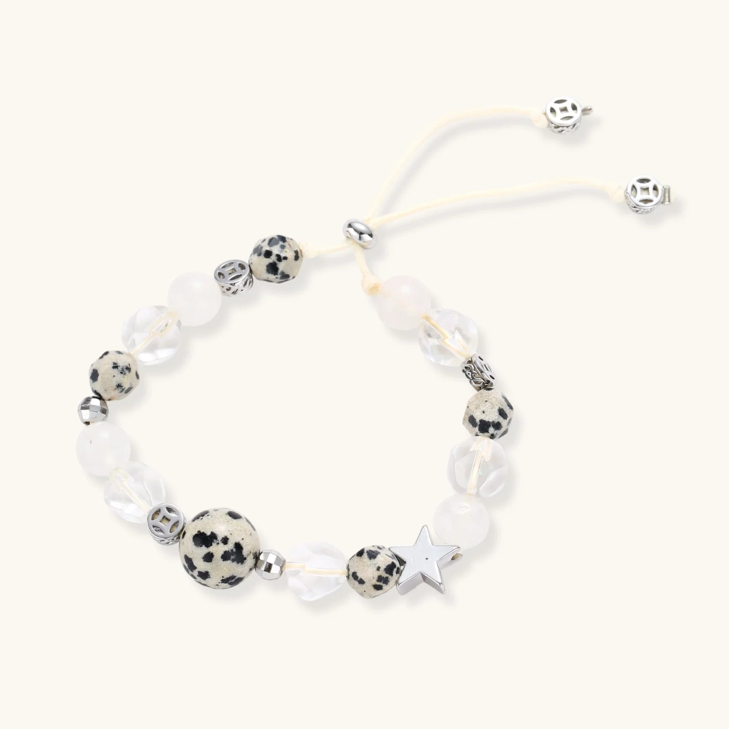 Cosmic Dalmatian Bracelet with dalmatian-spotted centerpiece, frosted quartz beads, silver star charm, and adjustable ivory cord