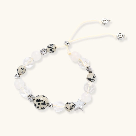 Cosmic Dalmatian Bracelet with dalmatian-spotted centerpiece, frosted quartz beads, silver star charm, and adjustable ivory cord