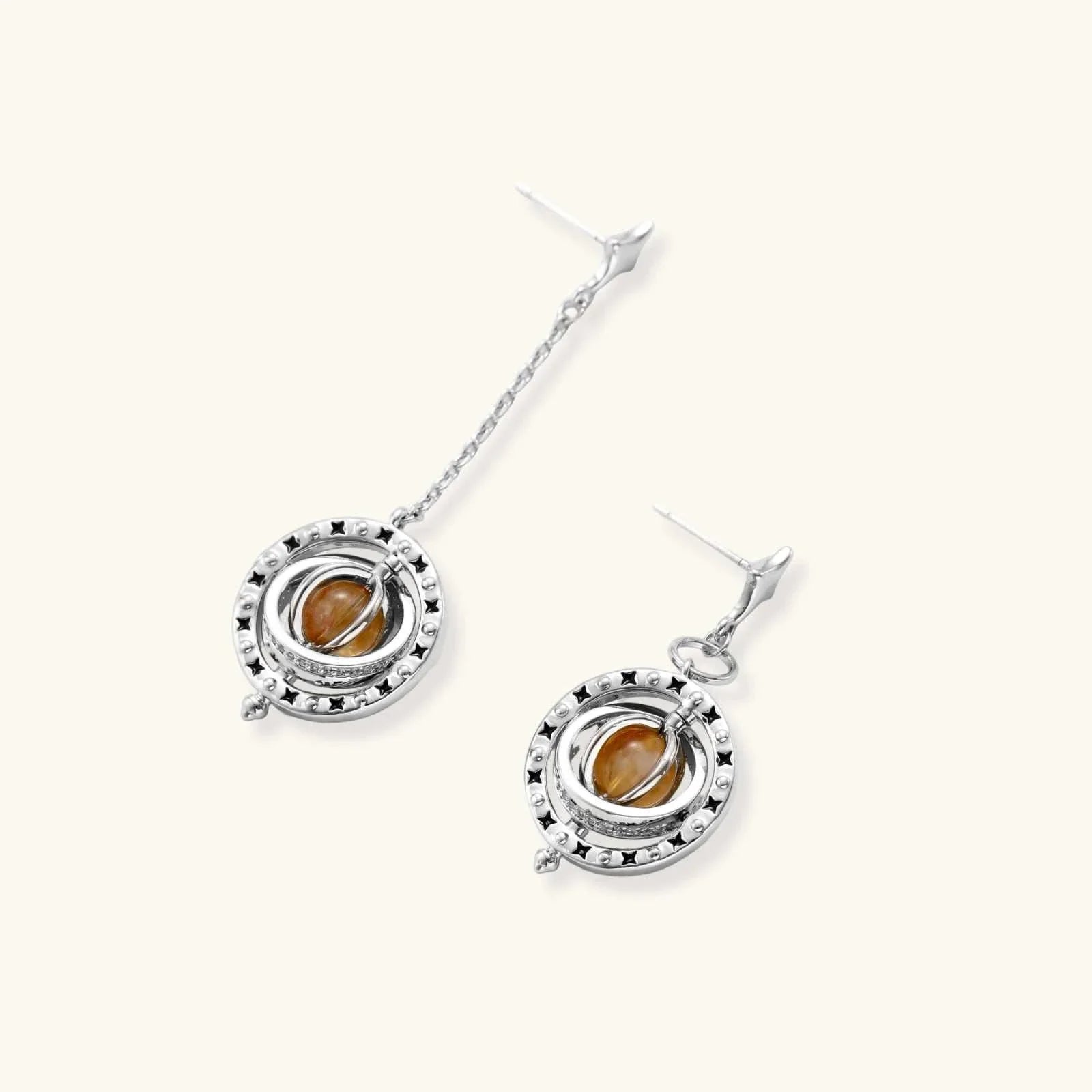 Orbital asymmetric earrings with star-shaped post, black enamel stars, and honey-gold cabochon in silver-toned ring from Najera Studio