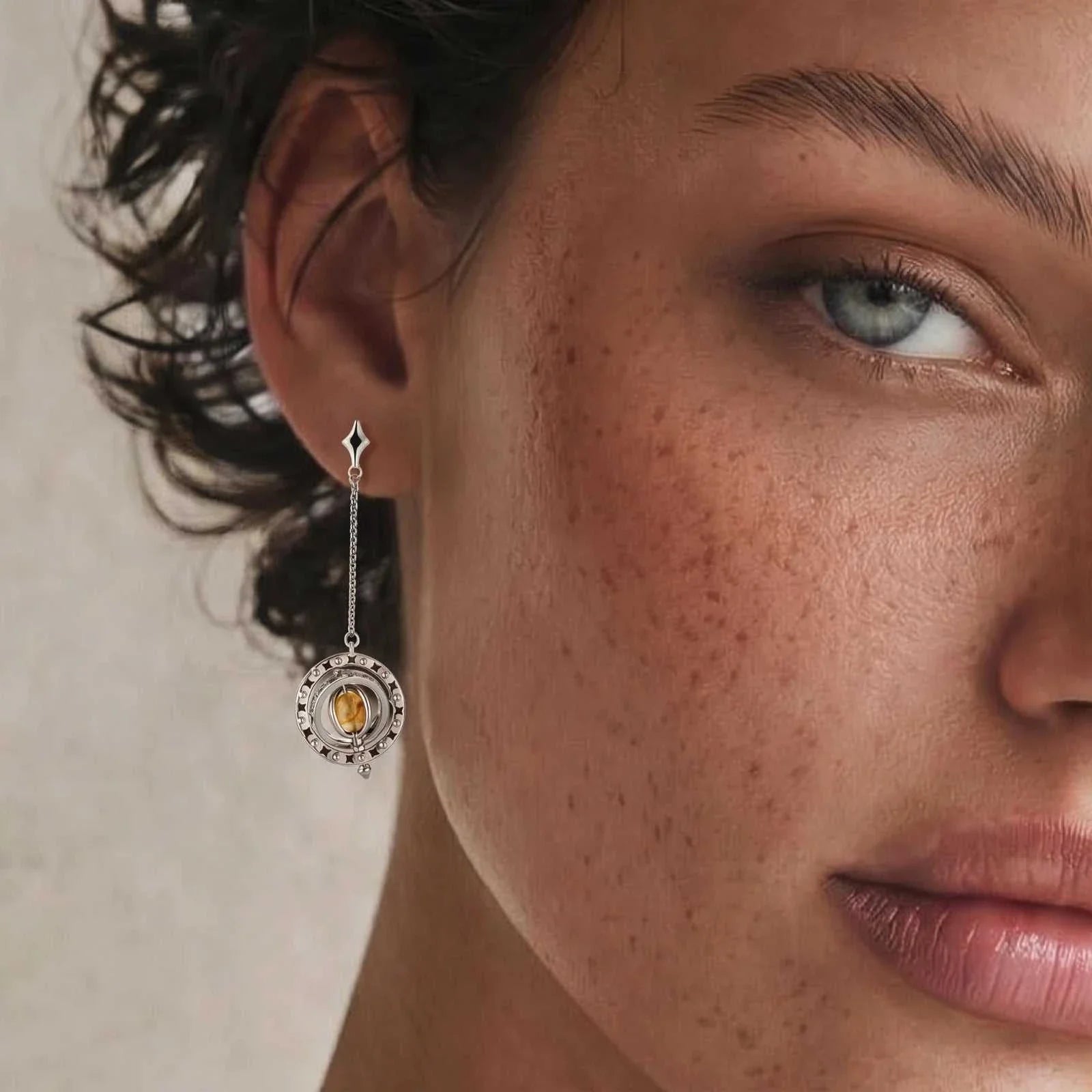 Orbital asymmetric earrings with star-shaped post, silver ring with black enamel stars, and honey-gold cabochon orbit by Najera Studio